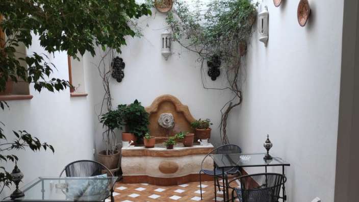 Ein kleiner Raum mit Tischen und Stühlen und einem Brunnen