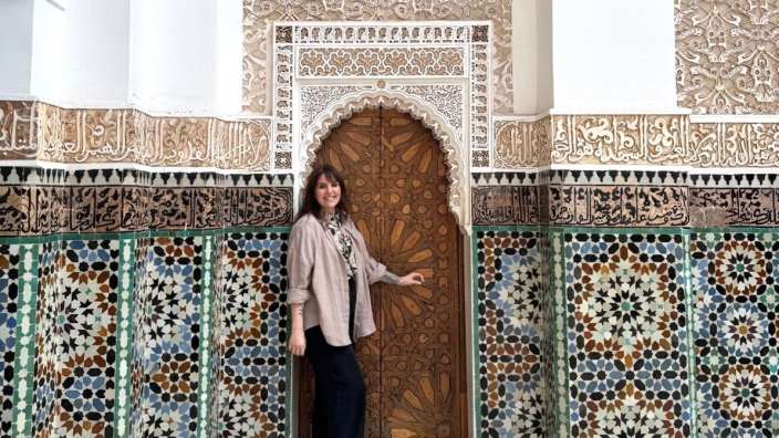 Eine Frau steht vor einer Tür mit arabischem Schriftzug