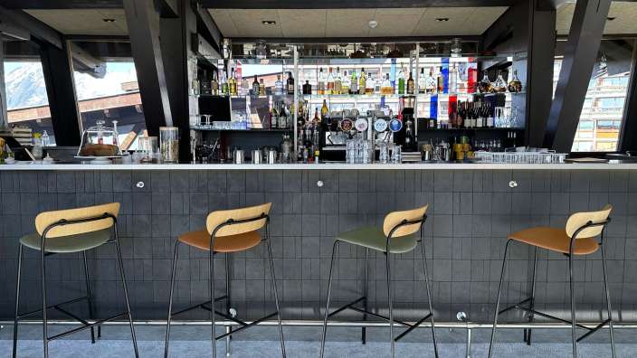 Barhocker stehen an einer Bar mit vielen Getränken