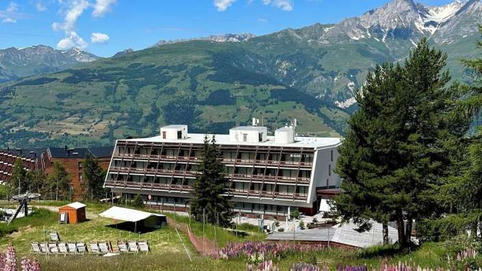 Ein großes Gebäude steht inmitten einer Bergkette