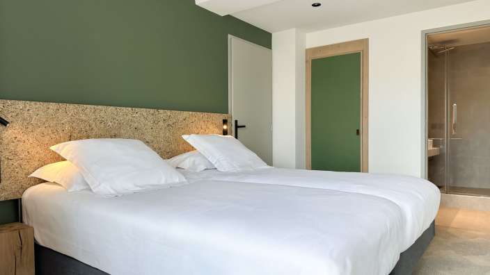 Ein Hotelzimmer mit zwei Betten und einer grünen Tür