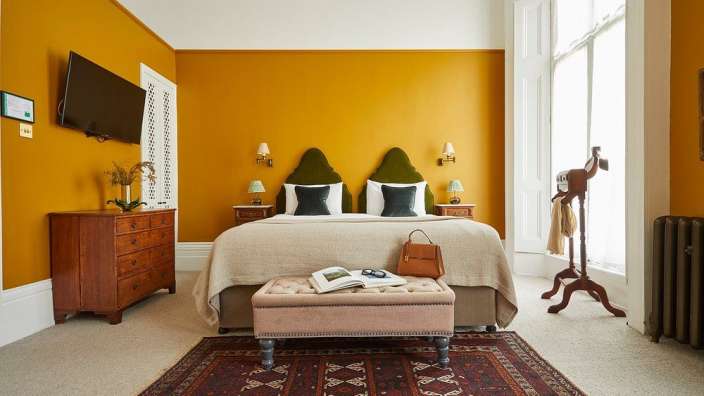 Ein Schlafzimmer mit gelben Wänden und einem Bett