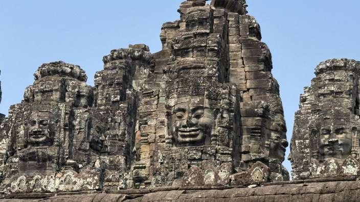 Eine Gruppe von Steinskulpturen mit Gesichtern darauf