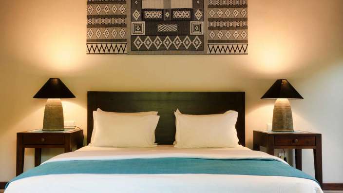 Ein Schlafzimmer mit zwei Nachttischen und einem Gemälde an der Wand