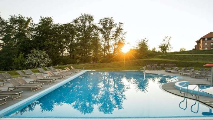 Ein großer Swimmingpool mit Liegestühlen umgeben