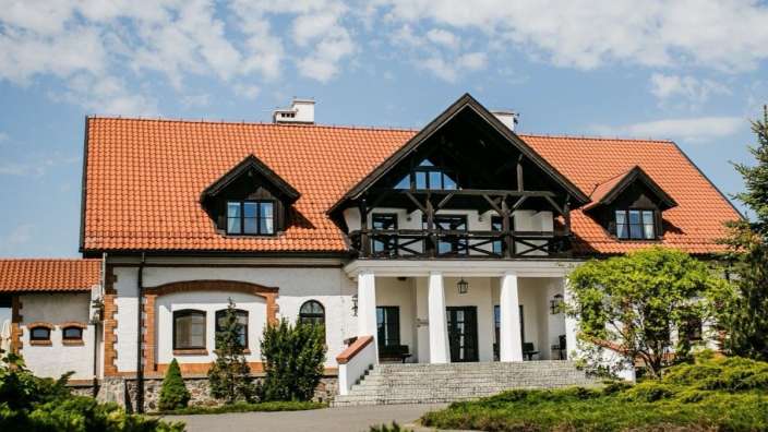 Ein großes weißes Haus mit einem roten Dach