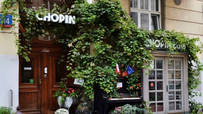 Ein schwarzes klavier steht vor einem chopin-cafe