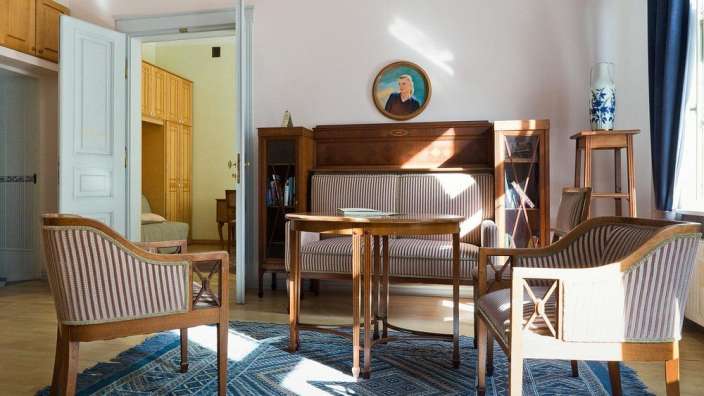 Ein Wohnzimmer mit Möbeln und einem Gemälde an der Wand