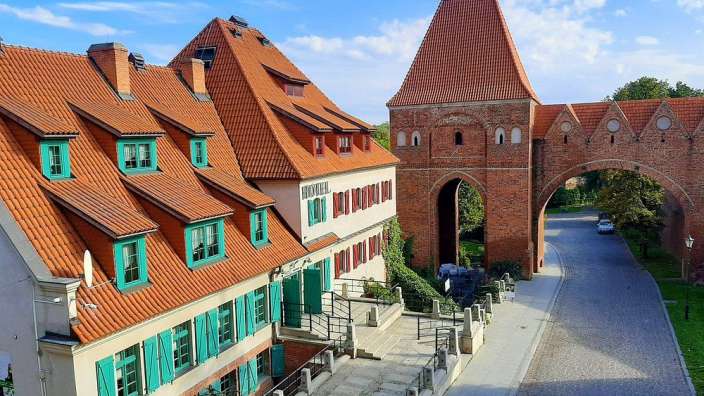 Eine Reihe von Gebäuden mit roten Dächern und grünen Fensterläden