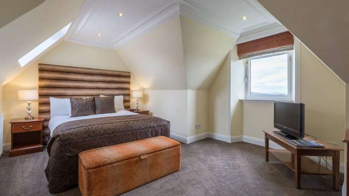 Ein Schlafzimmer mit einem Bett und einem Fernseher