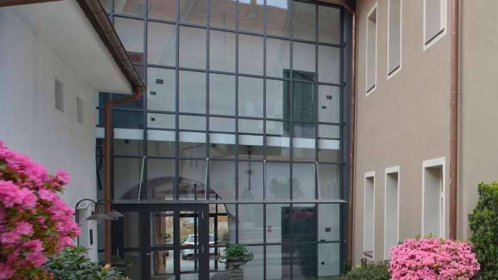 Ein Gebäude mit vielen Fenstern und rosa Blumen