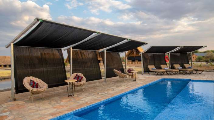 Ein Swimmingpool mit Liegestühlen und Sonnenschirmen umgeben