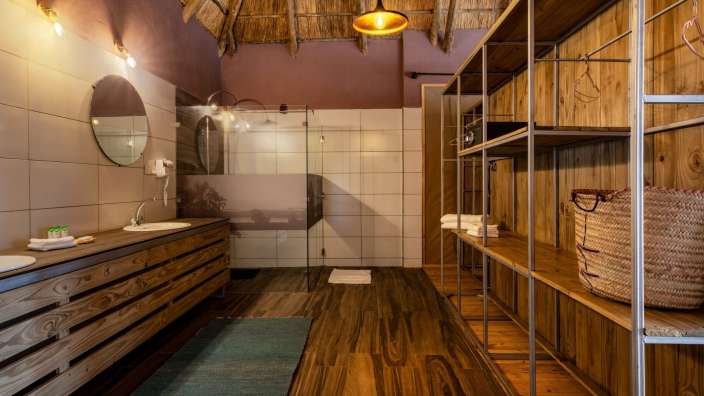 Ein Badezimmer mit Waschbecken und Regalen aus Holz