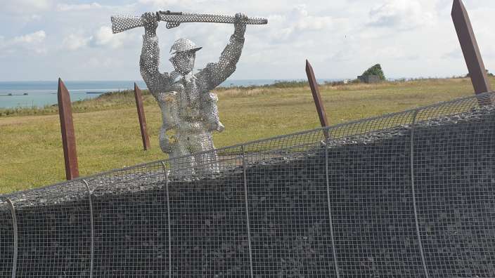 Eine Metallstatue eines Mannes, der eine Waffe hält