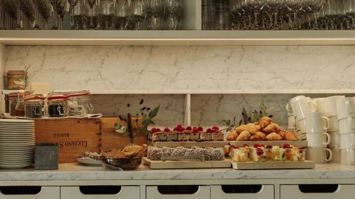 Ein Buffettisch mit Desserts und einer Holzkiste mit der Aufschrift " luciano "