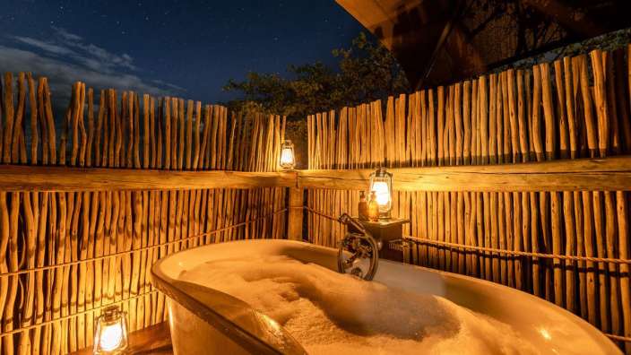 Eine Badewanne mit Schaum und Laternen davor