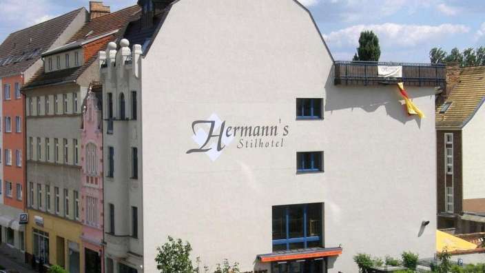 Ein weißes Gebäude mit dem Namen hermann 's stilhotel darauf