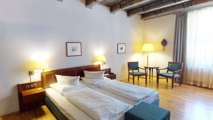 Ein Hotelzimmer mit zwei Betten und zwei Stühlen