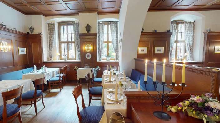 Ein Esszimmer mit vielen Tischen und Stühlen und Kerzen