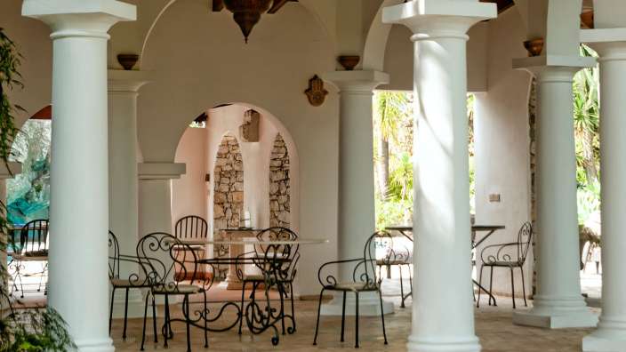 Eine weiße Veranda mit einem Tisch und Stühlen darauf