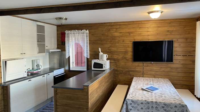 Eine Küche mit einem Tisch und einem Fernseher