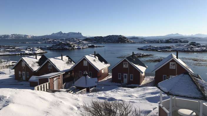 Eine Reihe von schneebedeckten Häusern mit Blick auf den Ozean