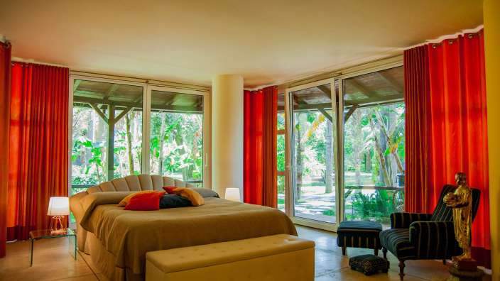 Ein Schlafzimmer mit einem Bett und roten Vorhängen