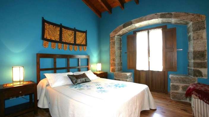Ein Schlafzimmer mit blauen Wänden und einem Bett