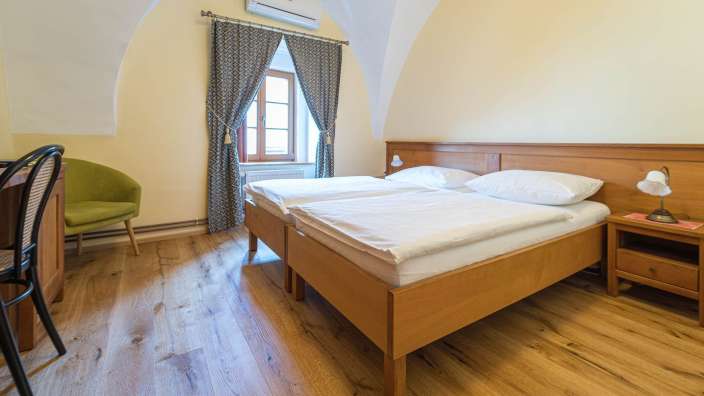 Ein Schlafzimmer mit zwei Betten und einem grünen Stuhl