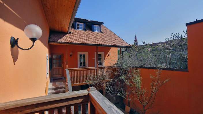 Ein orangefarbenes Gebäude mit einem Holzbalkon