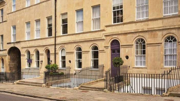 Ein Gebäude mit einer lila Tür und weißen Fenstern