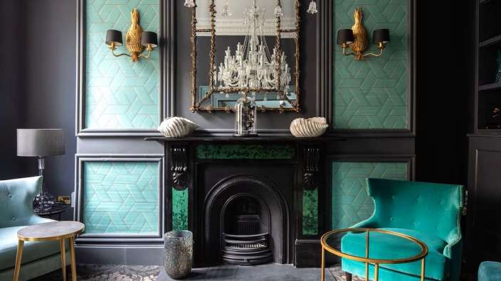 Ein Wohnzimmer mit grünen Wänden und einem Kamin
