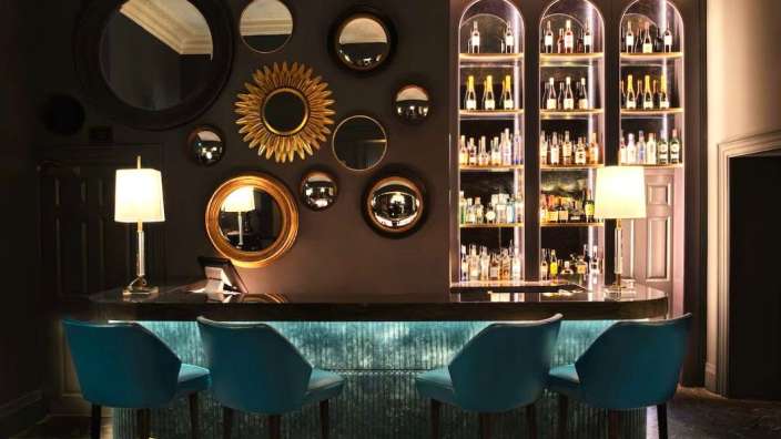 Eine Bar mit blauen Hockern und Spiegeln an der Wand