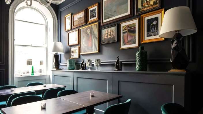 Ein Esszimmer mit Tisch und Stühlen und Bildern an der Wand