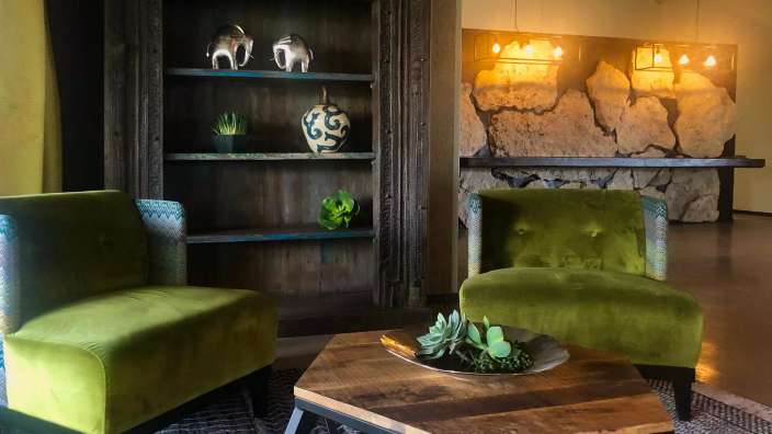 Ein Wohnzimmer mit grünen Stühlen und einem Holztisch
