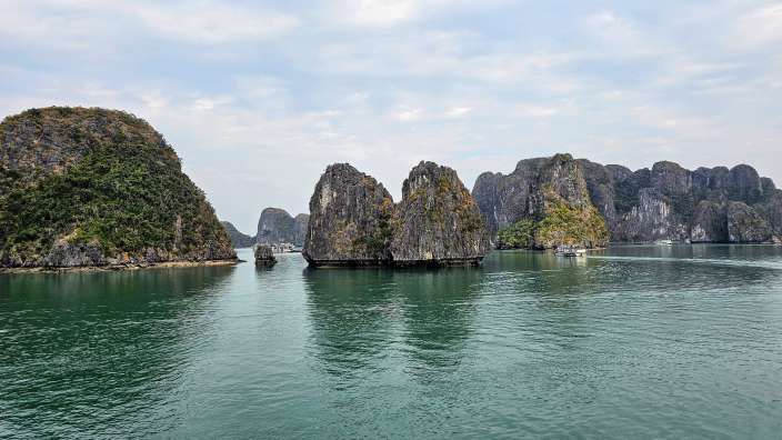Ein Boot fährt durch einen See mit vielen Felsen im Hintergrund