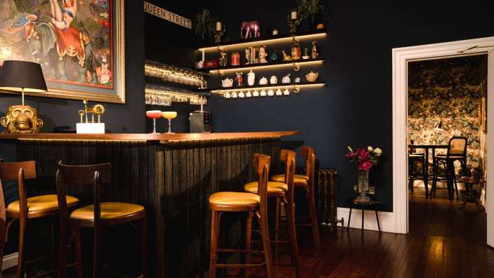 Eine Bar mit einem Schild an der Wand, das Queen Street sagt