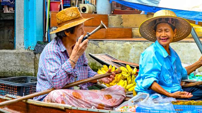 Eine Frau sitzt in einem Boot und spricht auf einem Handy