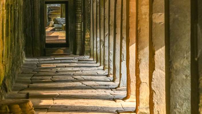 Die Sonne scheint durch die Säulen eines Gebäudes