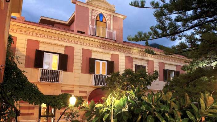 Ein großes rosa und weißes Gebäude mit einem Balkon