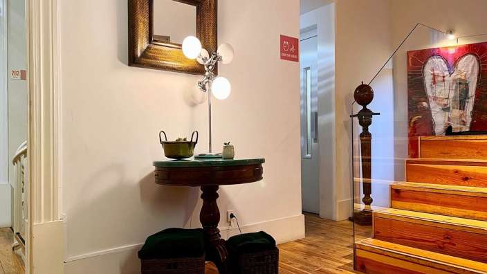 Ein kleiner Tisch mit einer Lampe darauf steht neben einer Treppe