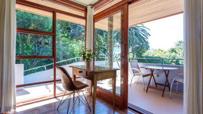 Ein Schreibtisch und ein Stuhl in einem Raum mit vielen Fenstern