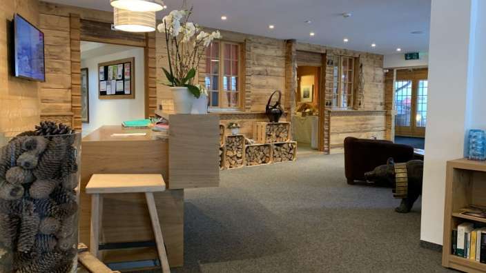 Ein Holztisch mit einer Vase mit Tannenzapfen darauf