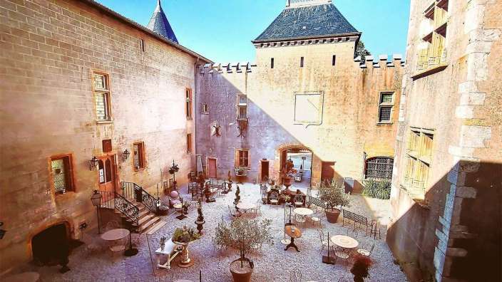 Ein kleiner Hof mit Tischen und Stühlen in einem Gebäude