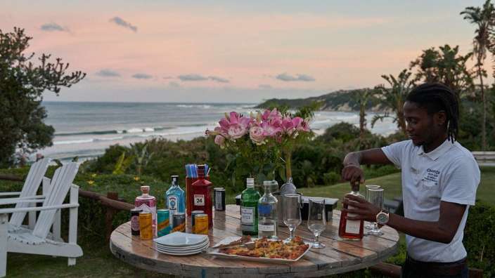 Ein Mann in einem weißen Hemd steht vor einem Tisch voller Flaschen