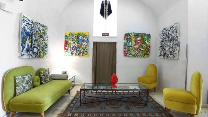 Ein Wohnzimmer mit grüner Couch und gelben Stühlen