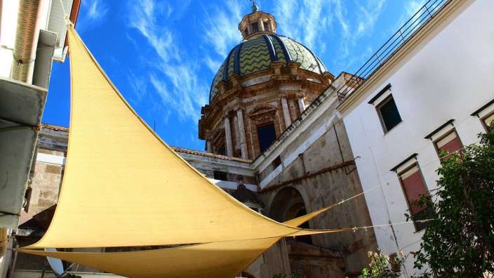 Ein Gebäude mit einer Kuppel und einem Sonnenschirm davor