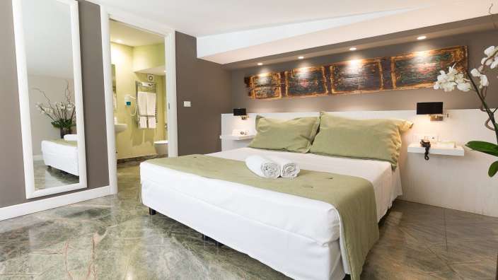 Ein Hotelzimmer mit einem Bett und einem Spiegel