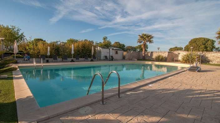 Ein großer Swimmingpool mit vielen Sonnenschirmen umgeben