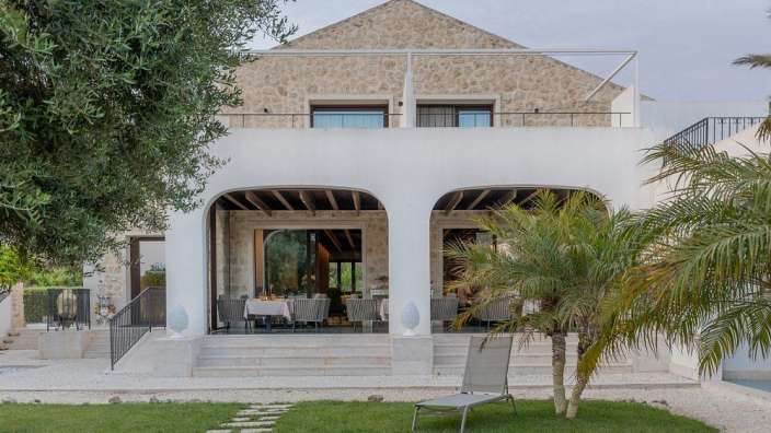 Ein weißes Haus mit einem Tisch und Stühlen darauf